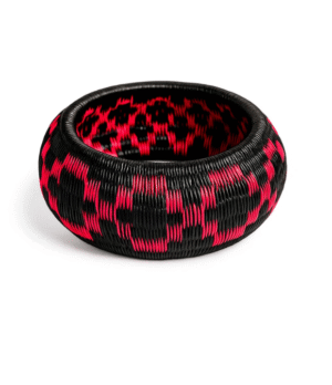 Pulsera artesanal Wounaan en fibra de werregue negro y fucsia hecha a mano en el Chocó.