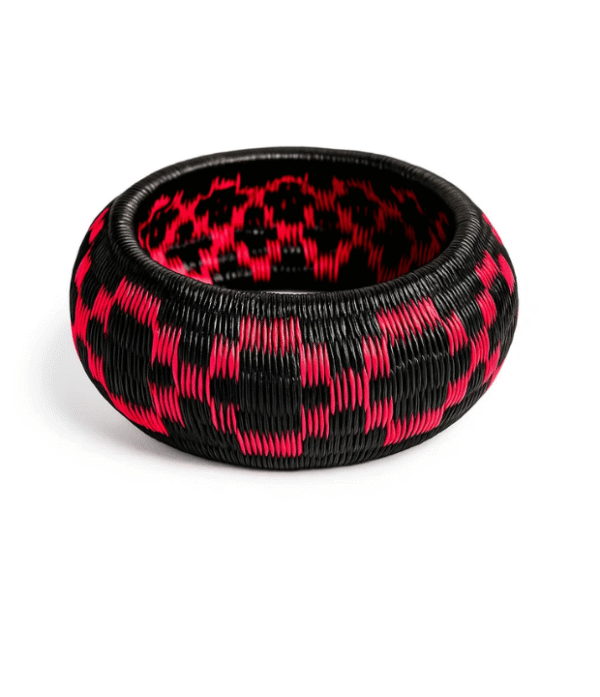 Pulsera artesanal Wounaan en fibra de werregue negro y fucsia hecha a mano en el Chocó.