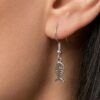 mujer usando aretes esqueleto de pez plateado