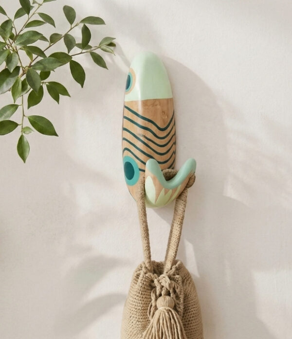 Perchero de pez Lunar en ambiente decorativo Perchero artesanal de pez con diseño Lunar utilizado como perchero decorativo y funcional para colgar un bolso tejido en una pared interior.
