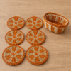 Set de portavasos de esparto con diseño de naranja y canasto artesanal.