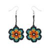 Aretes de chaquiras Kamentsa en combinación azul turquesa, naranja y negro sobre fondo blanco.