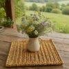 Florero con flores silvestres sobre portacalientes de fique tejido en telar