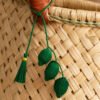 Charm artesanal de limones decorando un bolso Charm para bolso de fruta en palma de iraca colocado en un bolso tejido