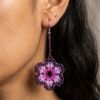 Primer plano de modelo luciendo aretes de chaquiras Kamentsa rosados en forma de flor.